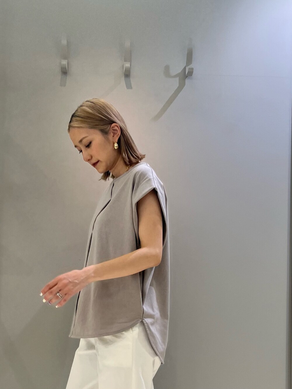 ホワイト系のその他パンツ、ブラック系のサンダル、ベージュ系のTシャツ/カットソーを着用したレディースの春コーディネートの2枚目の写真