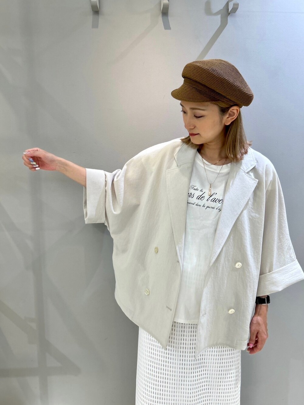 ベージュ系のテーラードジャケット、ホワイト系のスカート、ホワイト系のTシャツ/カットソーを着用したレディースの夏コーディネートの6枚目の写真