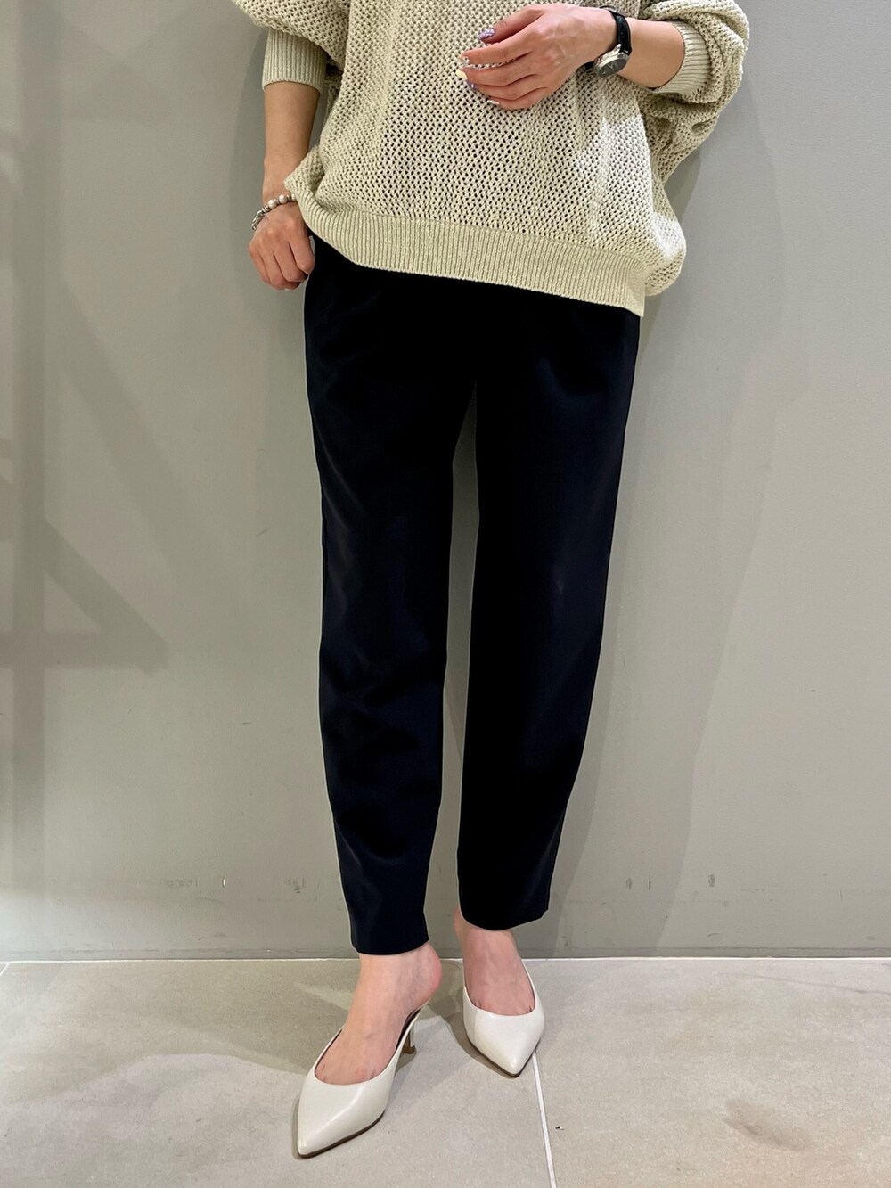 ベージュ系のハンドバッグ、ゴールド系のニット/セーター、ブルー系のその他パンツを着用したレディースの春コーディネートの4枚目の写真