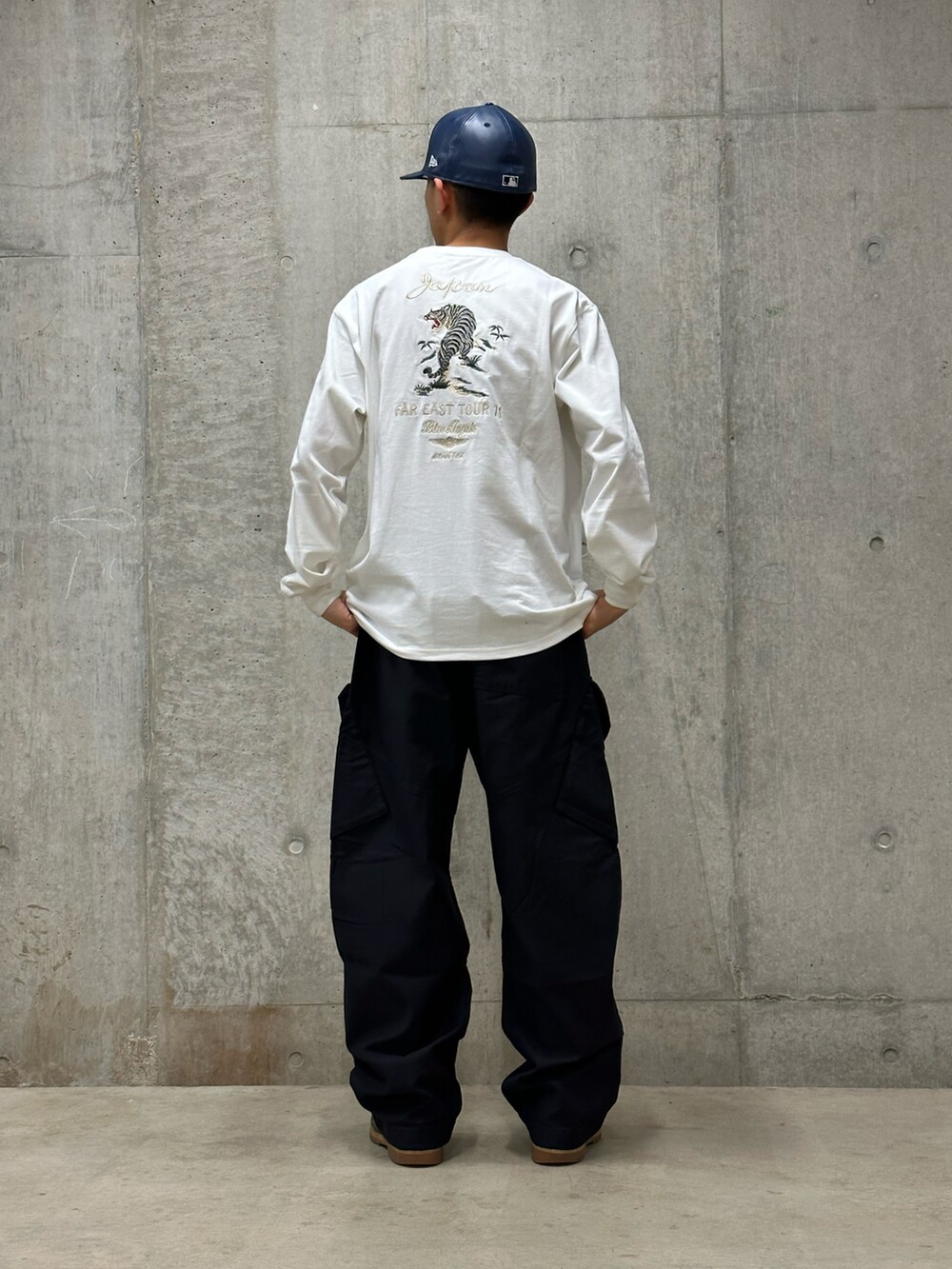 ブラック系のカーゴパンツ、ホワイト系のTシャツ/カットソーを着用したメンズの冬コーディネートの2枚目の写真