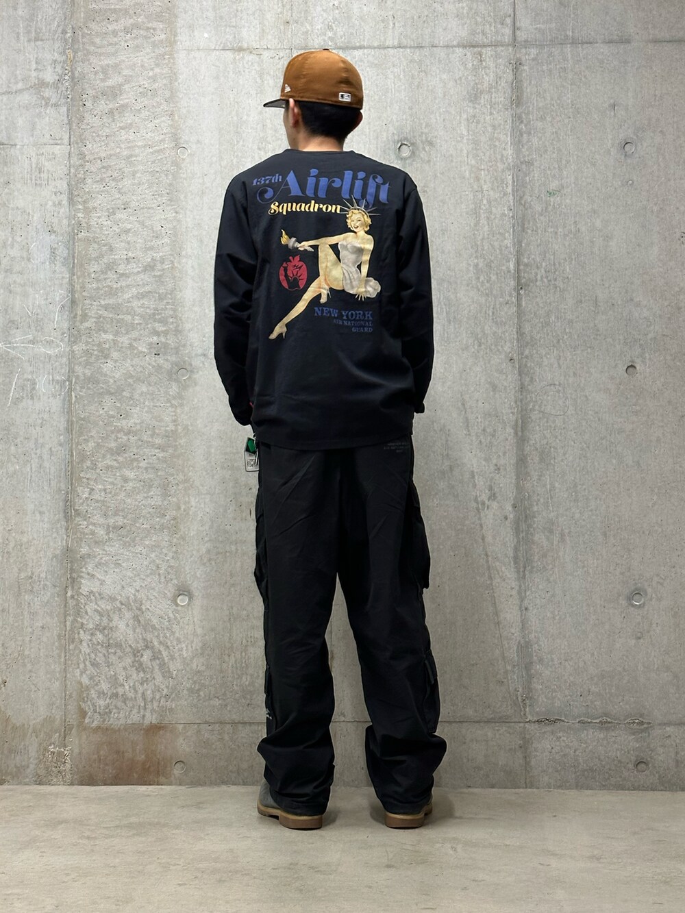 ブラック系のTシャツ/カットソー、グリーン系のカーゴパンツを着用したメンズの冬コーディネートの3枚目の写真