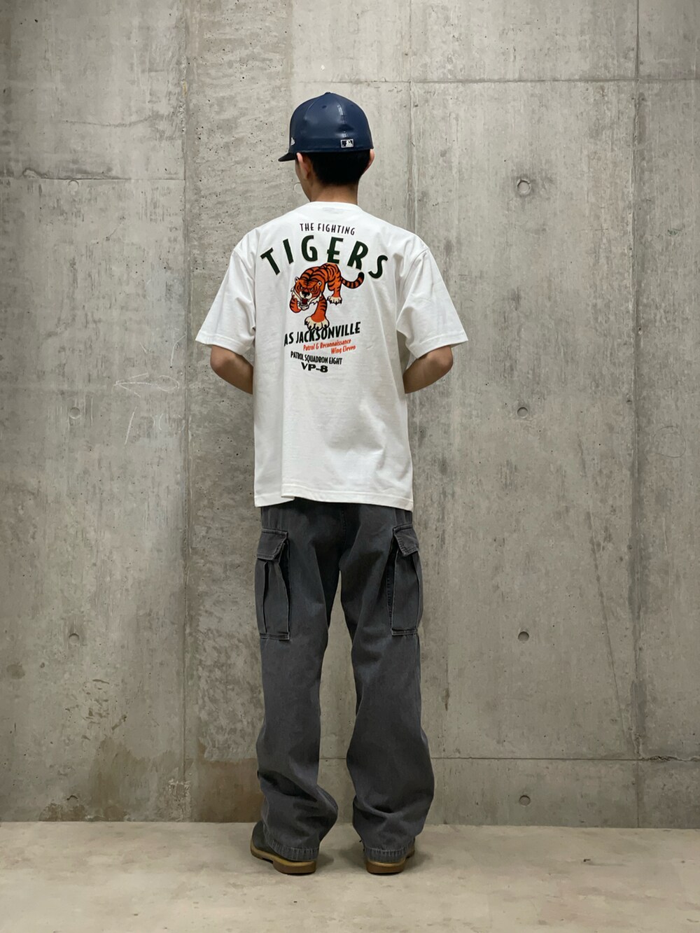 ブラック系のカーゴパンツ、ホワイト系のTシャツ/カットソーを着用したメンズの春コーディネートの3枚目の写真