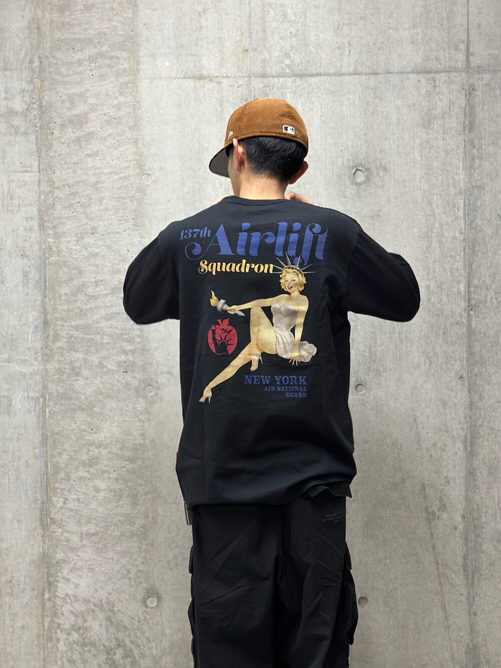 ブラック系のTシャツ/カットソー、グリーン系のカーゴパンツを着用したメンズの冬コーディネートの2枚目の写真