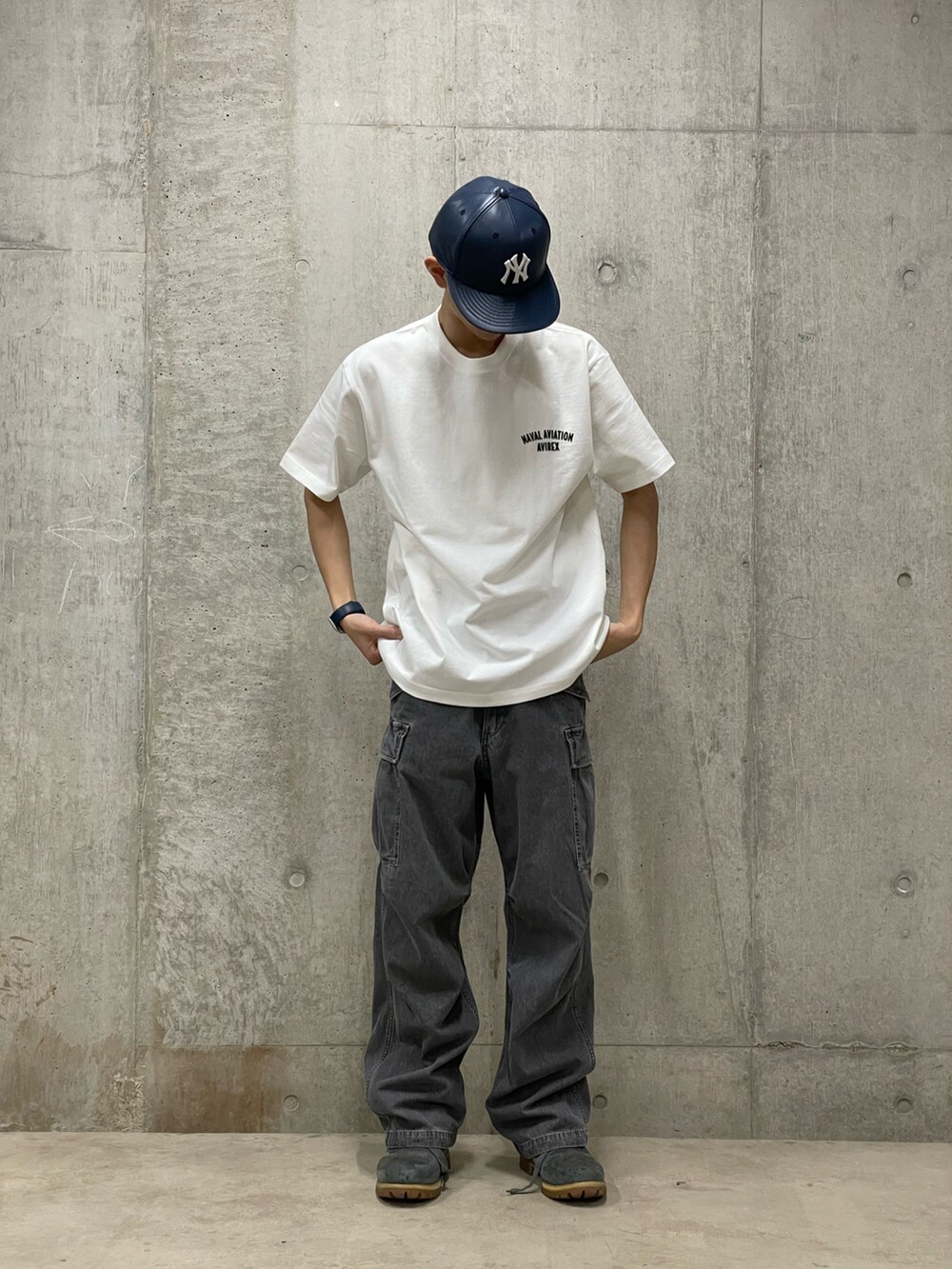 ブラック系のカーゴパンツ、ホワイト系のTシャツ/カットソーを着用したメンズの春コーディネートの2枚目の写真