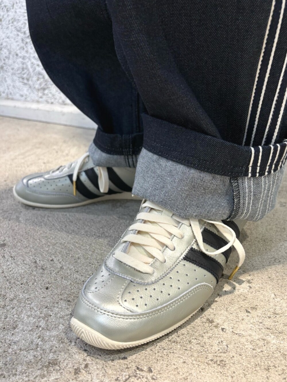 ブラック系のショルダーバッグ、ブルー系のデニムパンツ、ホワイト系のトップスを着用したメンズの夏コーディネートの4枚目の写真