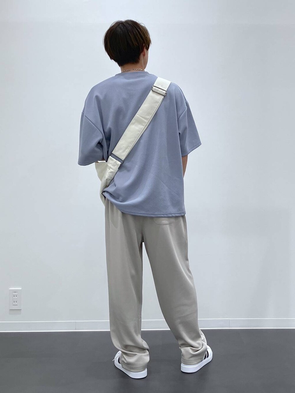 ブルー系のTシャツ/カットソー、ベージュ系のショルダーバッグ、ホワイト系のスニーカーを着用したメンズの夏コーディネートの3枚目の写真