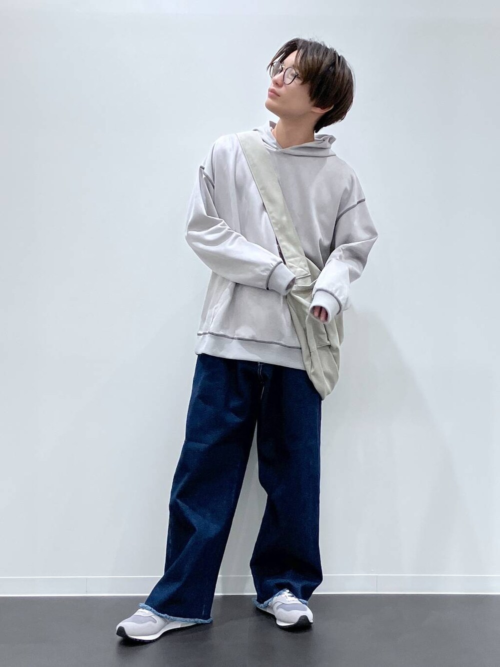 グレー系のショルダーバッグ、ブルー系のデニムパンツ、グレー系のスニーカーを着用したメンズの秋コーディネートの4枚目の写真