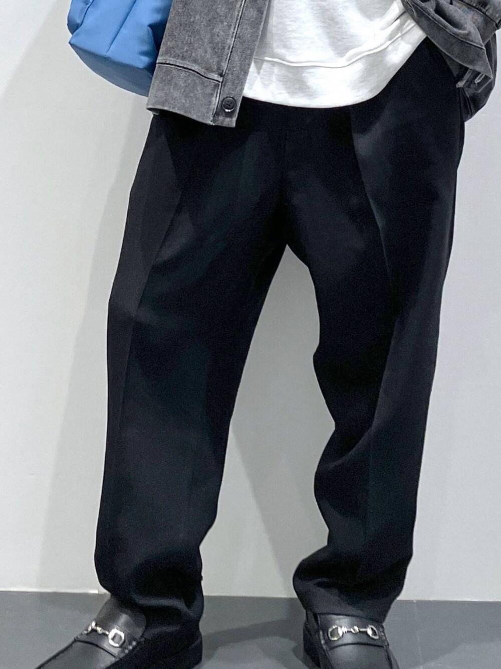 ブラック系のカーディガン/ボレロ、ブラック系のローファー、ブルー系のショルダーバッグを着用したメンズの春コーディネートの7枚目の写真