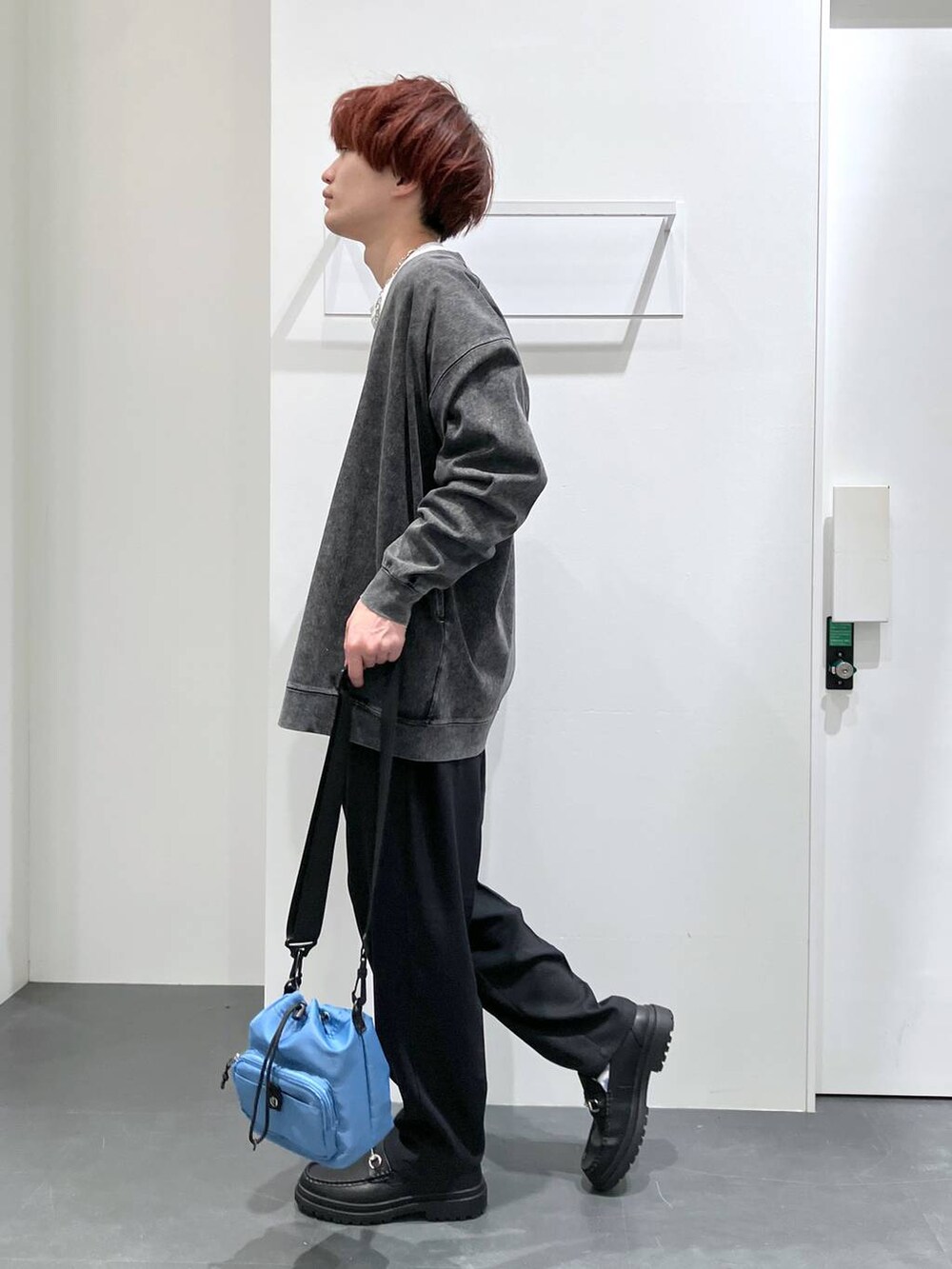 ブラック系のカーディガン/ボレロ、ブラック系のローファー、ブルー系のショルダーバッグを着用したメンズの春コーディネートの2枚目の写真