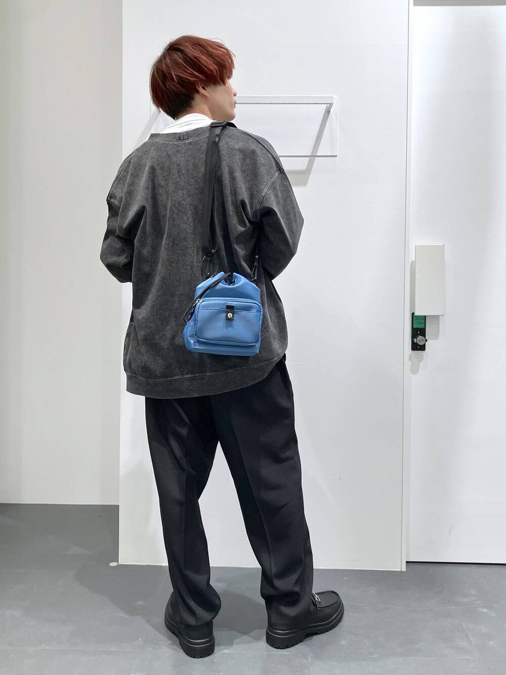 ブラック系のカーディガン/ボレロ、ブラック系のローファー、ブルー系のショルダーバッグを着用したメンズの春コーディネートの3枚目の写真