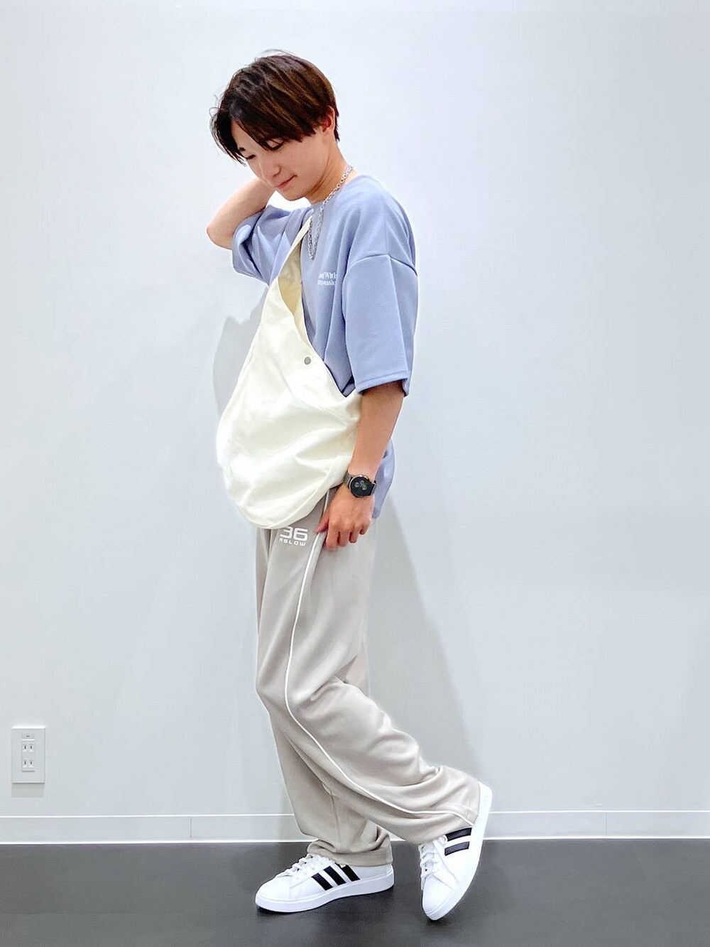 ブルー系のTシャツ/カットソー、ベージュ系のショルダーバッグ、ホワイト系のスニーカーを着用したメンズの夏コーディネートの6枚目の写真