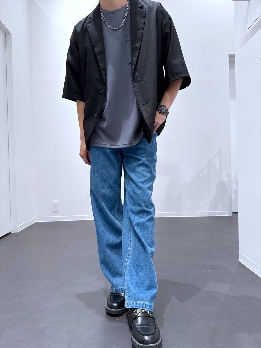 ブラック系のローファー、ブラック系のテーラードジャケット、ブルー系のデニムパンツを着用したメンズの夏コーディネートの4枚目の写真