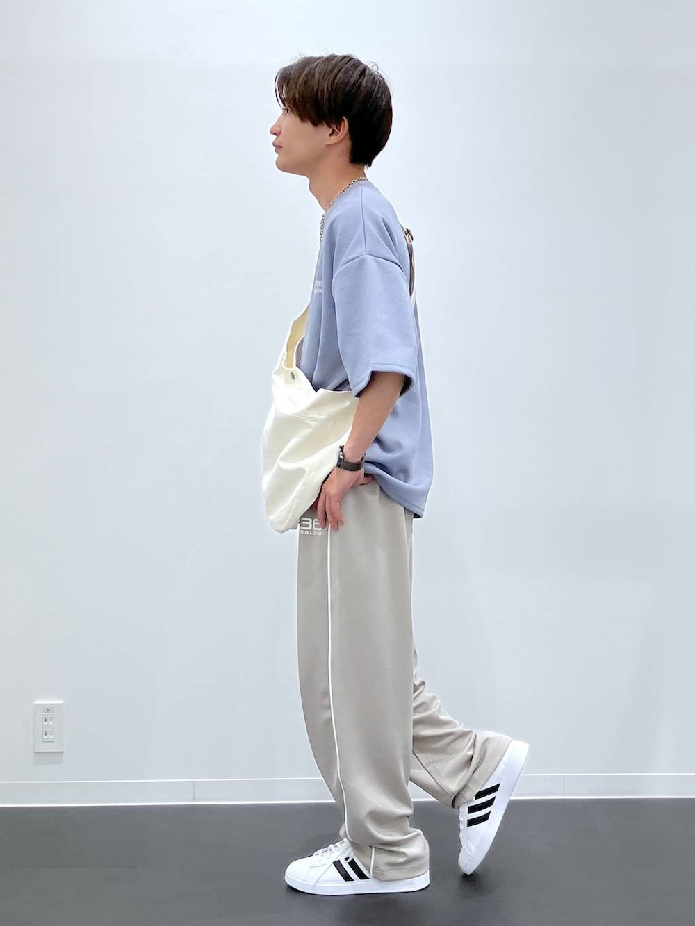 ブルー系のTシャツ/カットソー、ベージュ系のショルダーバッグ、ホワイト系のスニーカーを着用したメンズの夏コーディネートの2枚目の写真