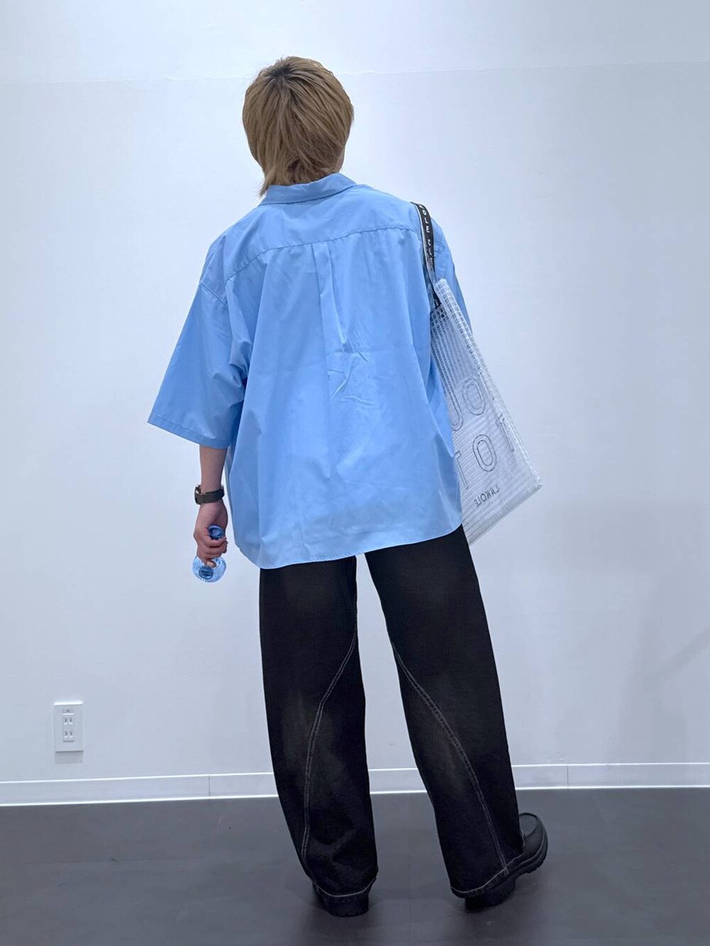 ブラック系のデニムパンツ、ブラック系のローファー、ホワイト系のTシャツ/カットソーを着用したメンズの夏コーディネートの3枚目の写真