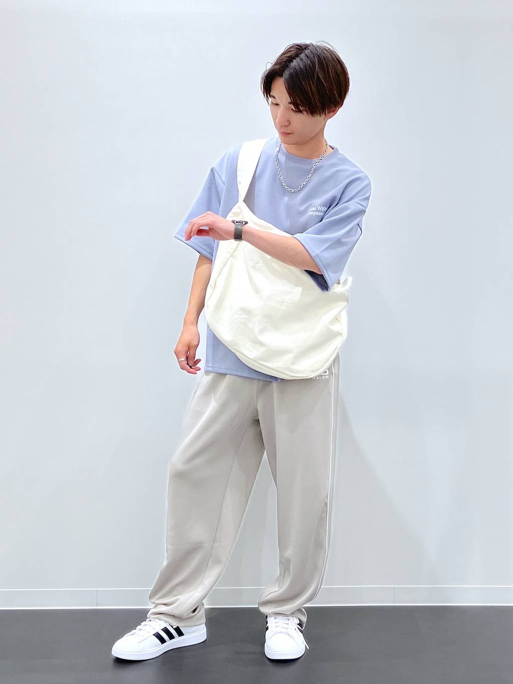 ブルー系のTシャツ/カットソー、ベージュ系のショルダーバッグ、ホワイト系のスニーカーを着用したメンズの夏コーディネートの5枚目の写真