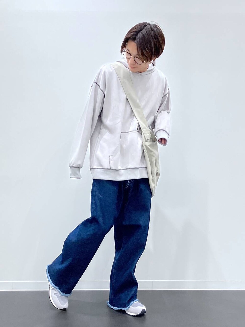 グレー系のショルダーバッグ、ブルー系のデニムパンツ、グレー系のスニーカーを着用したメンズの秋コーディネートの5枚目の写真