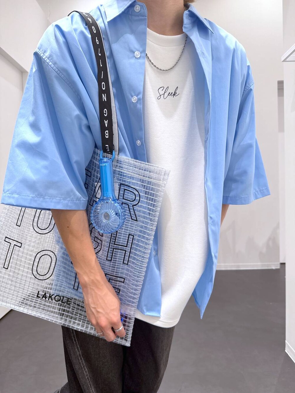 ブラック系のデニムパンツ、ブラック系のローファー、ホワイト系のTシャツ/カットソーを着用したメンズの夏コーディネートの5枚目の写真