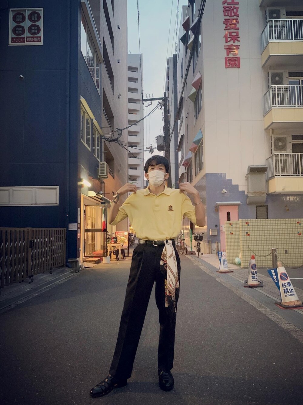 イエロー系のポロシャツ、ブラック系のサンダルを着用したメンズの春コーディネートの5枚目の写真