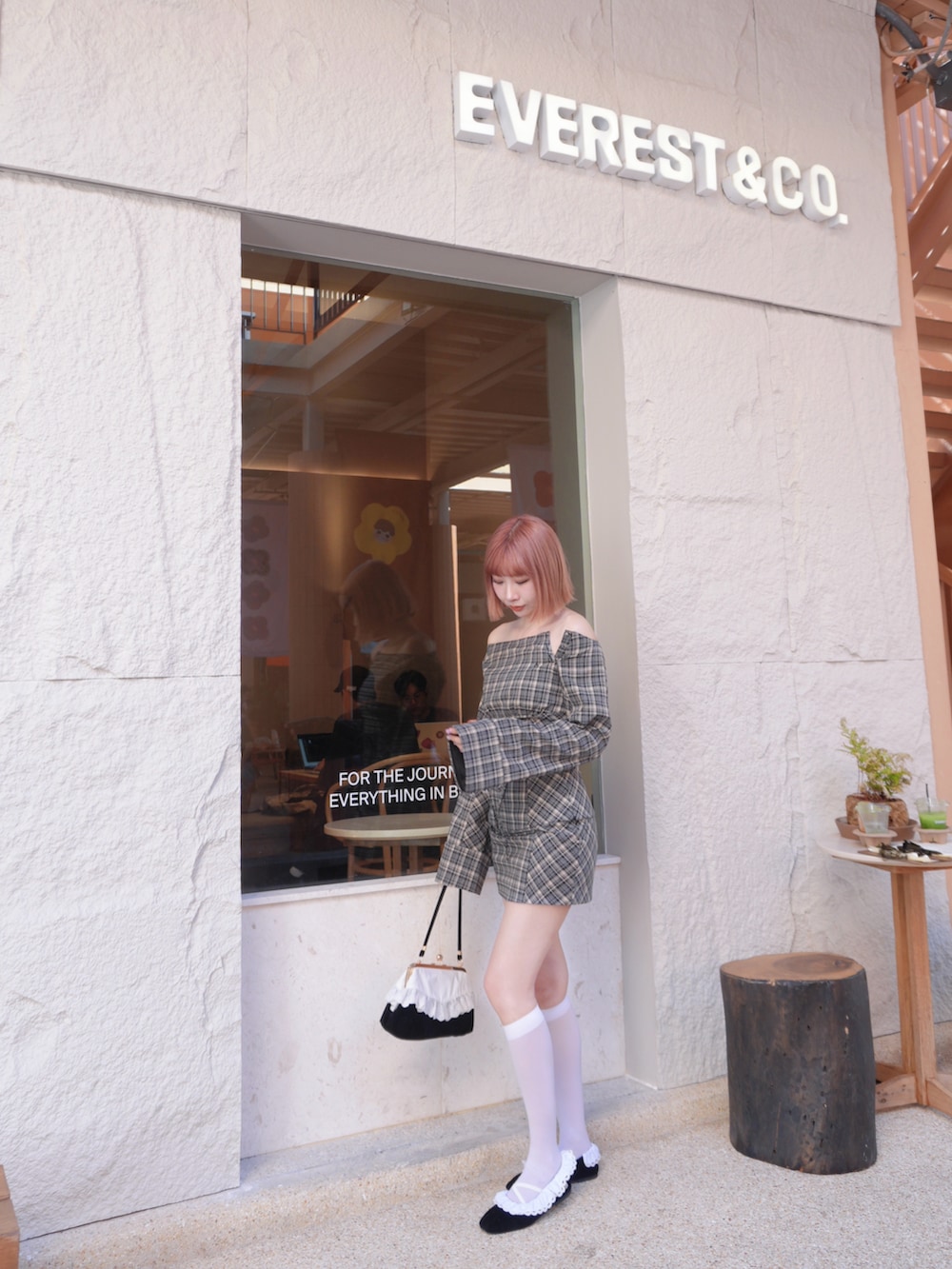 グレー系のシャツ/ブラウス、グレー系のスカート、ブラック系のハンドバッグを着用したレディースの冬コーディネートの2枚目の写真