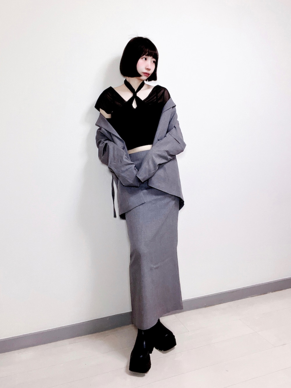 ブラック系のシャツ/ブラウス、グレー系のその他アウター、グレー系のスカートを着用したレディースの春コーディネートの2枚目の写真
