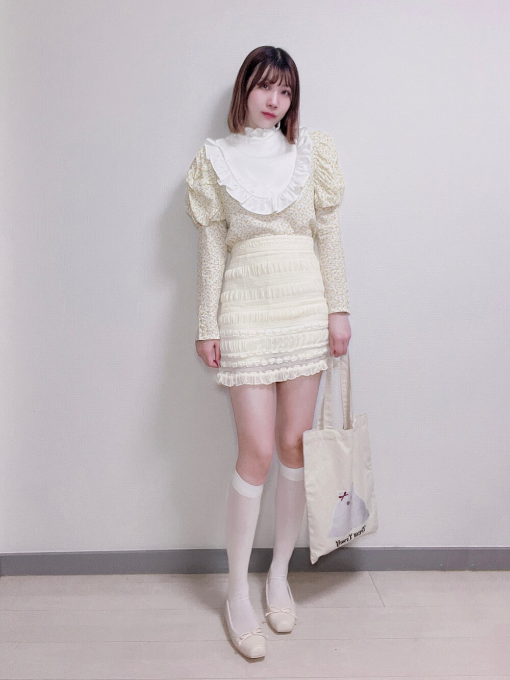 イエロー系のシャツ/ブラウス、ホワイト系のスカート、ホワイト系のバレエシューズを着用したレディースの秋コーディネートの3枚目の写真