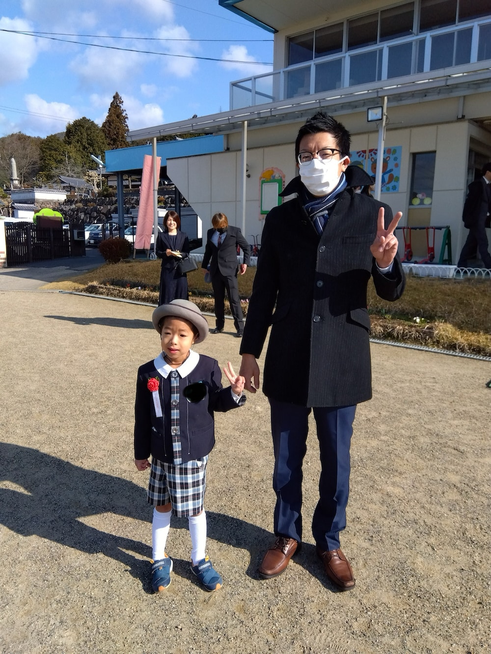 ベージュ系のニット/セーター、ブルー系のデニムパンツ、ブラック系のスニーカーを着用したメンズの春コーディネートの2枚目の写真