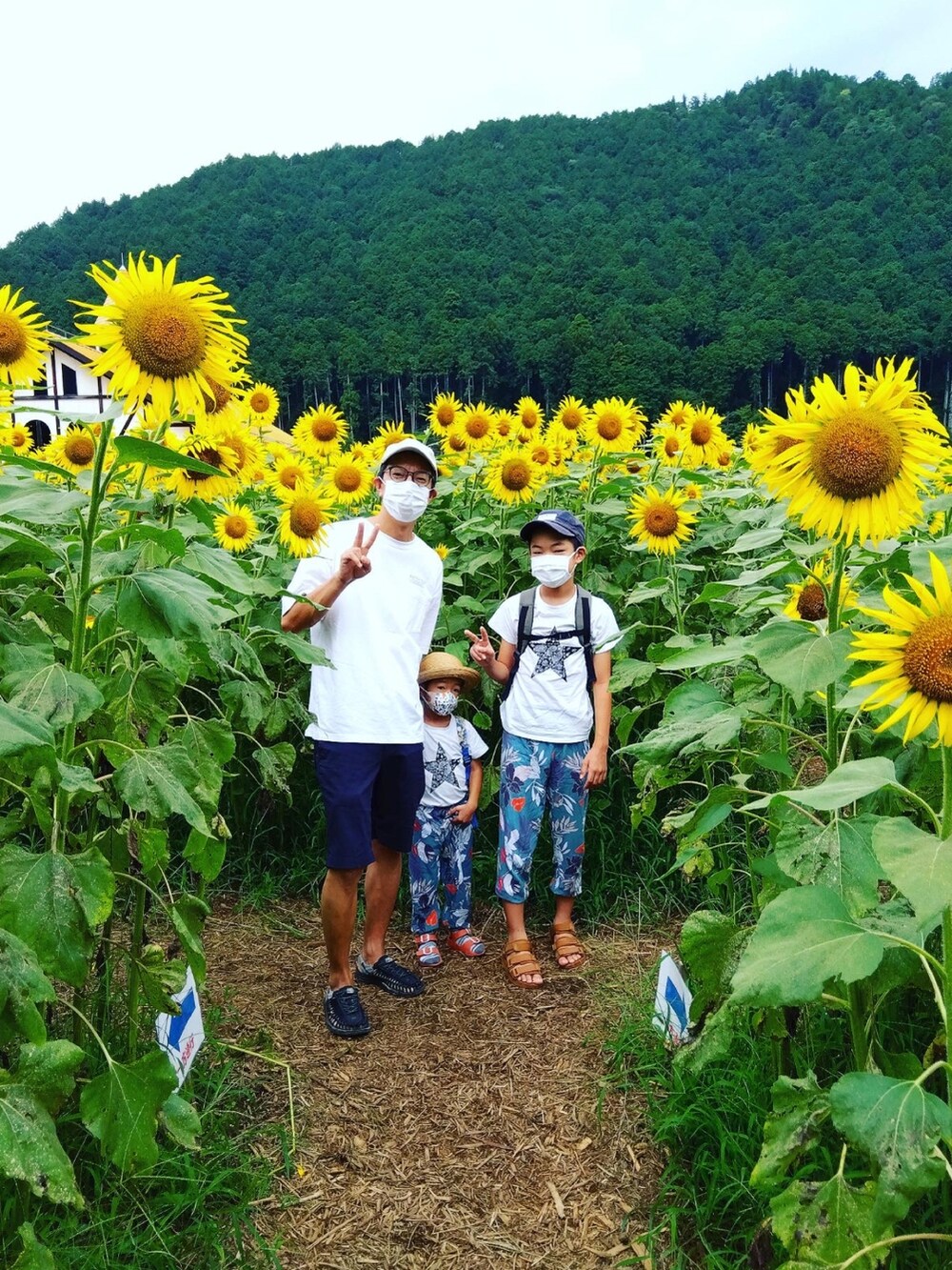 ホワイト系のTシャツ/カットソー、ブルー系のその他パンツ、ブラック系のサンダルを着用したメンズの夏コーディネートの2枚目の写真