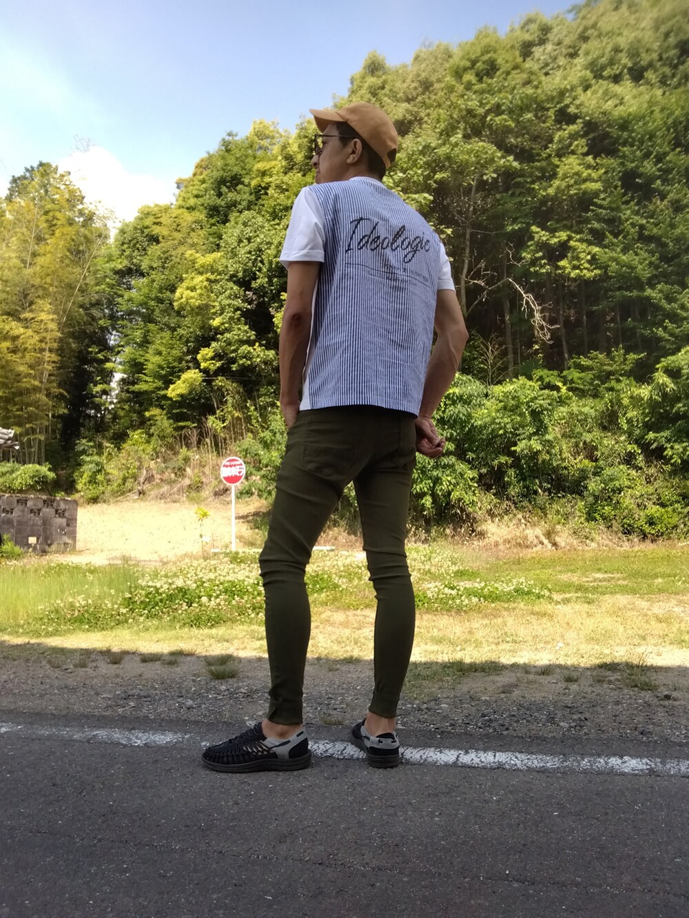 グリーン系のデニムパンツ、ブラック系のサンダル、ホワイト系のTシャツ/カットソーを着用したメンズの春コーディネートの2枚目の写真