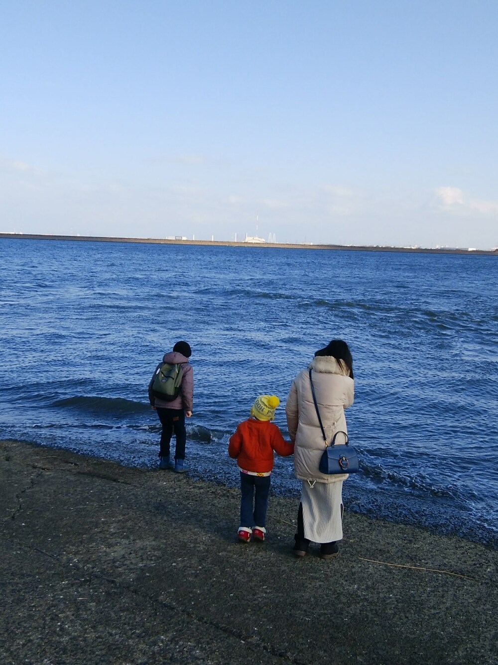 グリーン系のダウンジャケット/コート、ブルー系のデニムパンツ、ブラウン系のブーツを着用したメンズの冬コーディネートの3枚目の写真