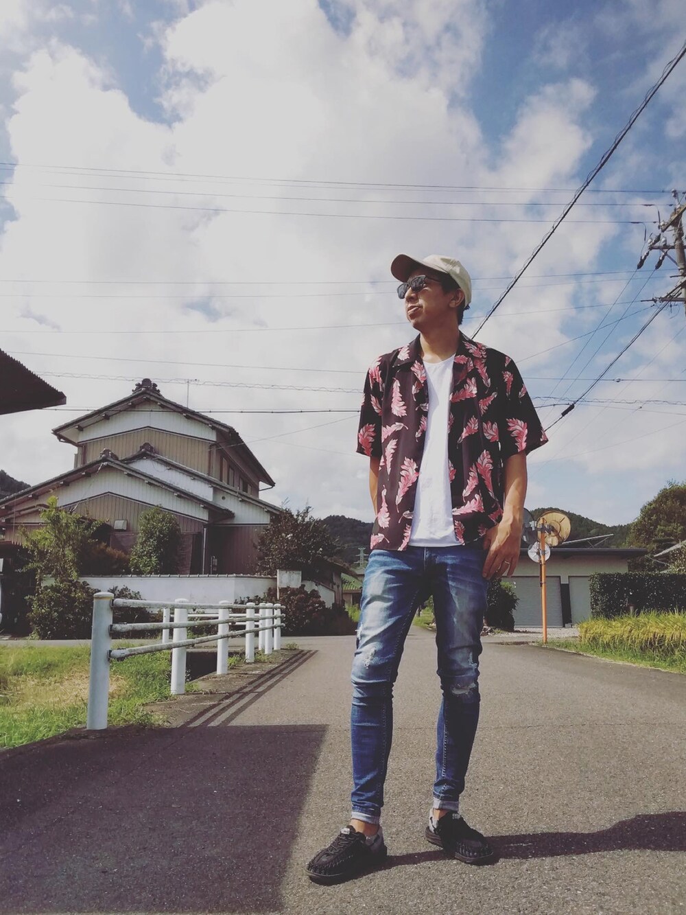 ホワイト系のTシャツ/カットソー、ブルー系のデニムパンツ、ブラック系のサンダルを着用したメンズの秋コーディネートの2枚目の写真