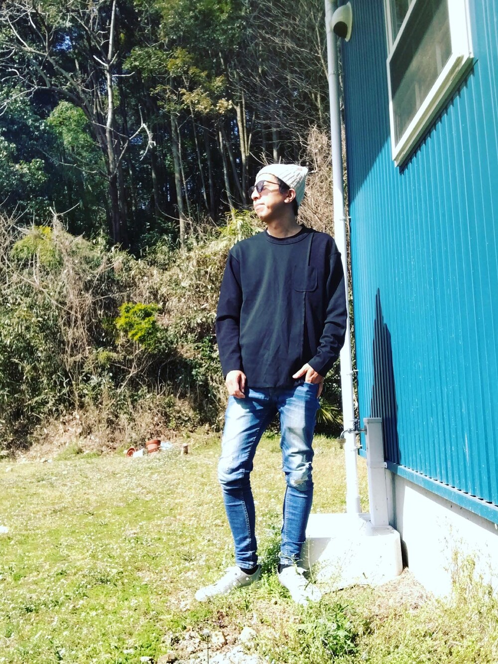 ブラック系のTシャツ/カットソー、ブルー系のデニムパンツ、グレー系のスニーカーを着用したメンズの春コーディネートの2枚目の写真