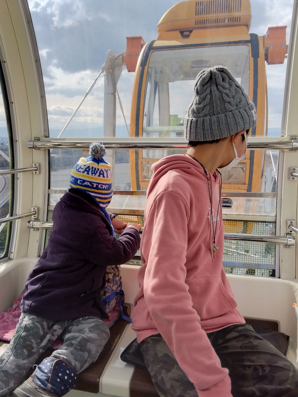 ブルー系のブルゾン、レッド系のニット/セーター、ブルー系のデニムパンツを着用したメンズの冬コーディネートの2枚目の写真