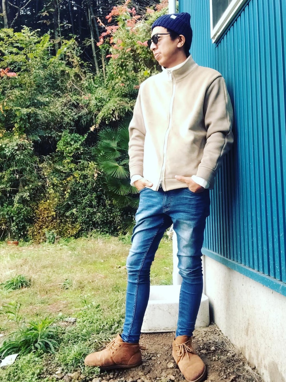 ベージュ系のブルゾン、ホワイト系のニット/セーター、ブルー系のデニムパンツを着用したメンズの秋コーディネートの2枚目の写真