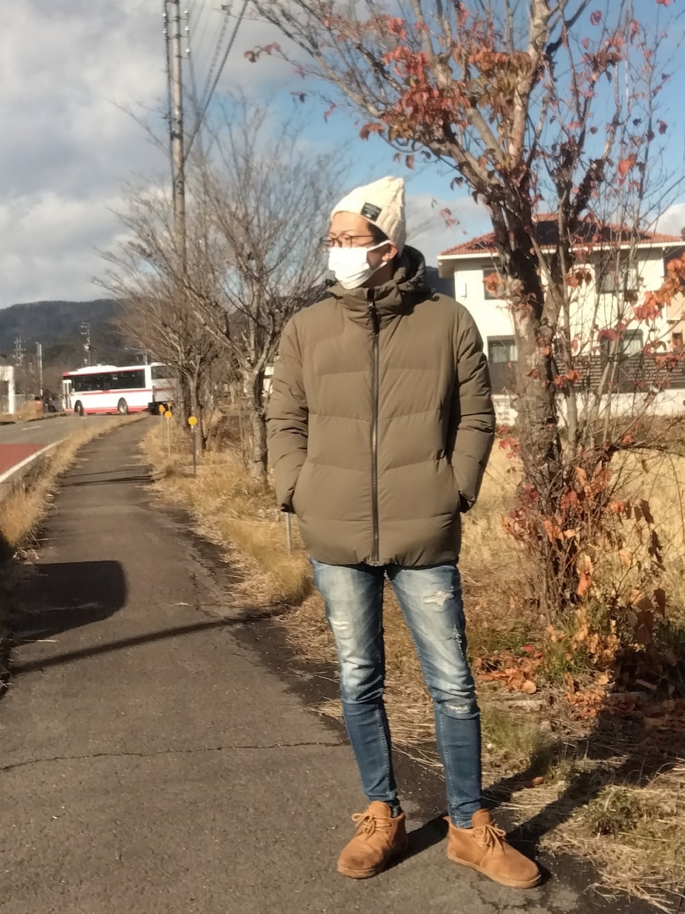 グリーン系のダウンジャケット/コート、ブルー系のデニムパンツ、ブラウン系のブーツを着用したメンズの冬コーディネートの2枚目の写真