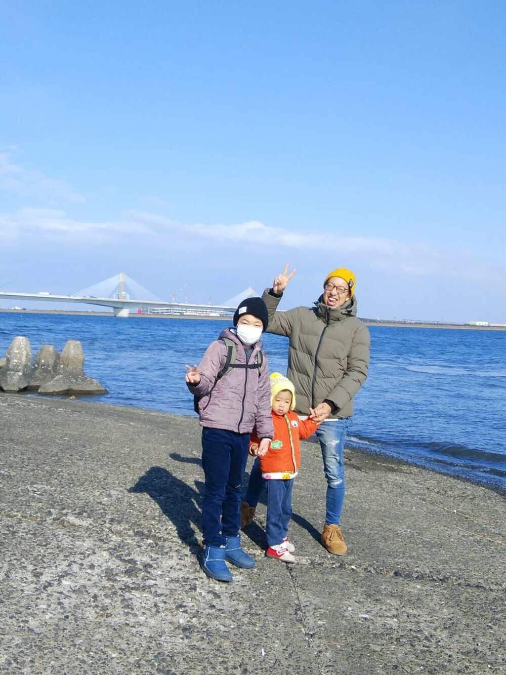 グリーン系のダウンジャケット/コート、ブルー系のデニムパンツ、ブラウン系のブーツを着用したメンズの冬コーディネートの2枚目の写真