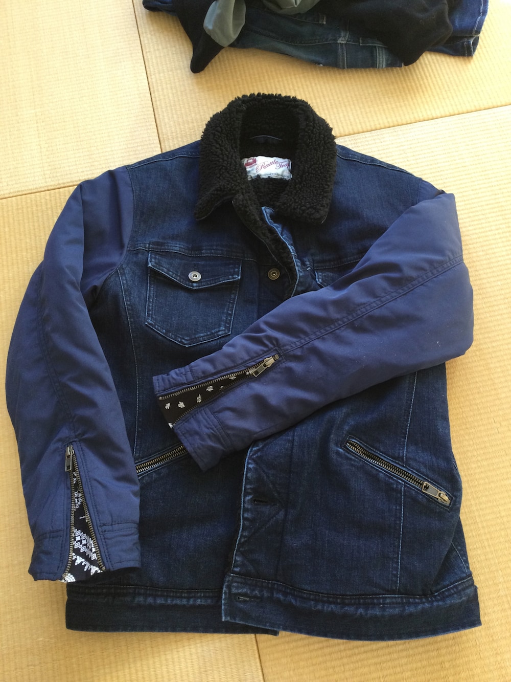 ホワイト系のニット/セーター、レッド系のシャツ/ブラウス、ブルー系のデニムパンツを着用したメンズの秋コーディネートの3枚目の写真