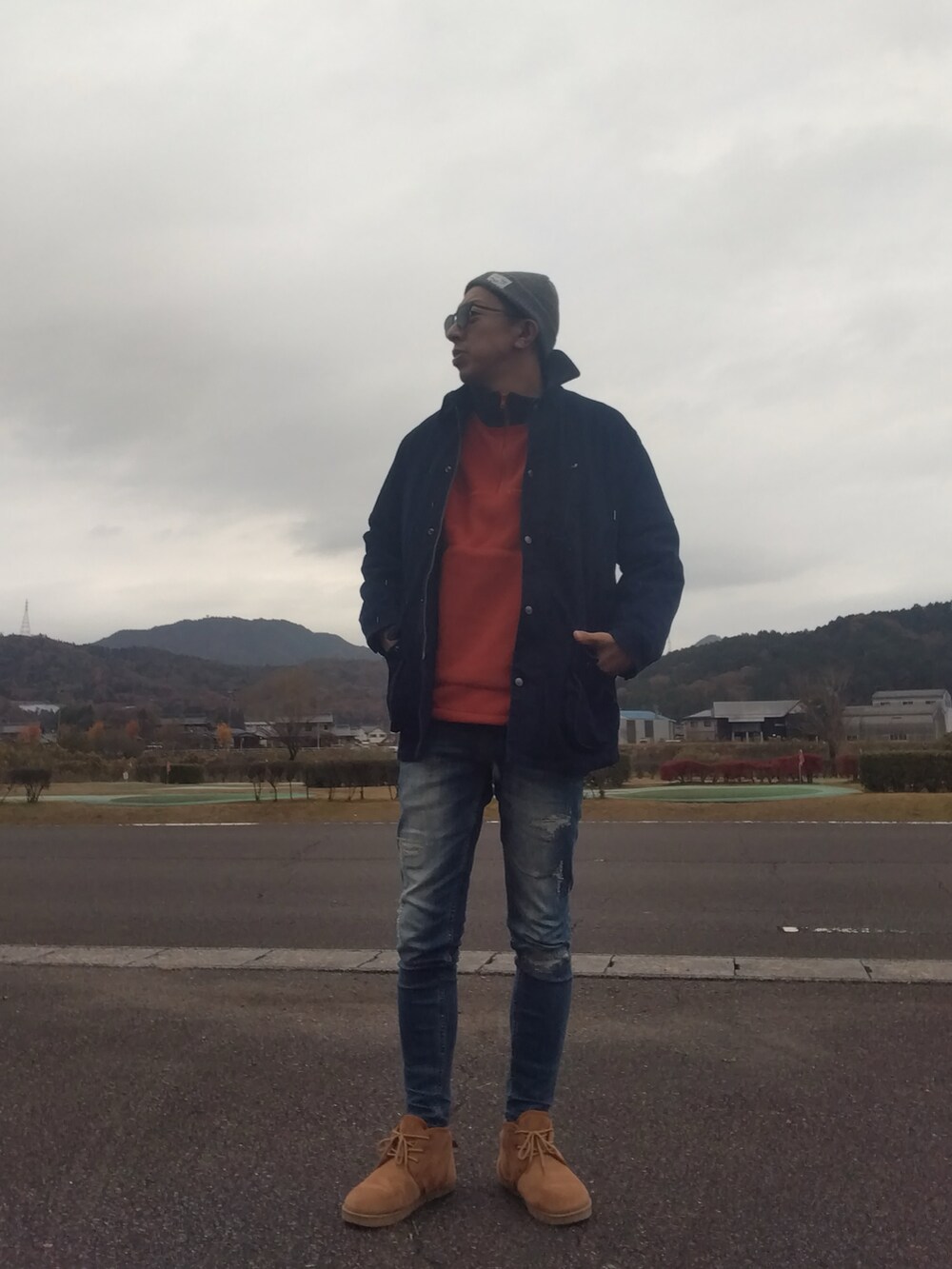 オレンジ系のスウェット、ブルー系のデニムジャケット、ブルー系のデニムパンツを着用したメンズの冬コーディネートの2枚目の写真