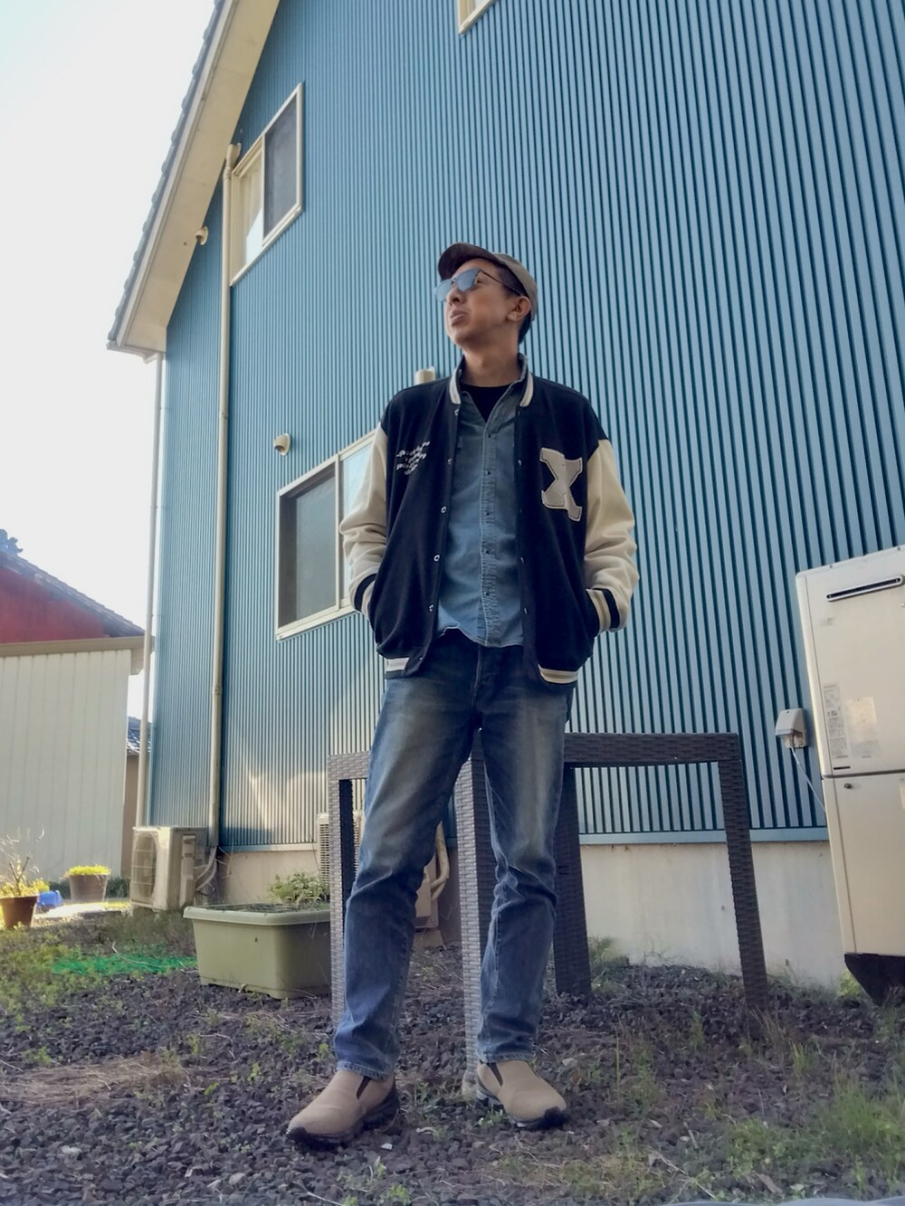 ブルー系のシャツ/ブラウス、ブラック系のスタジャン、ブルー系のデニムパンツを着用したメンズの秋コーディネートの2枚目の写真