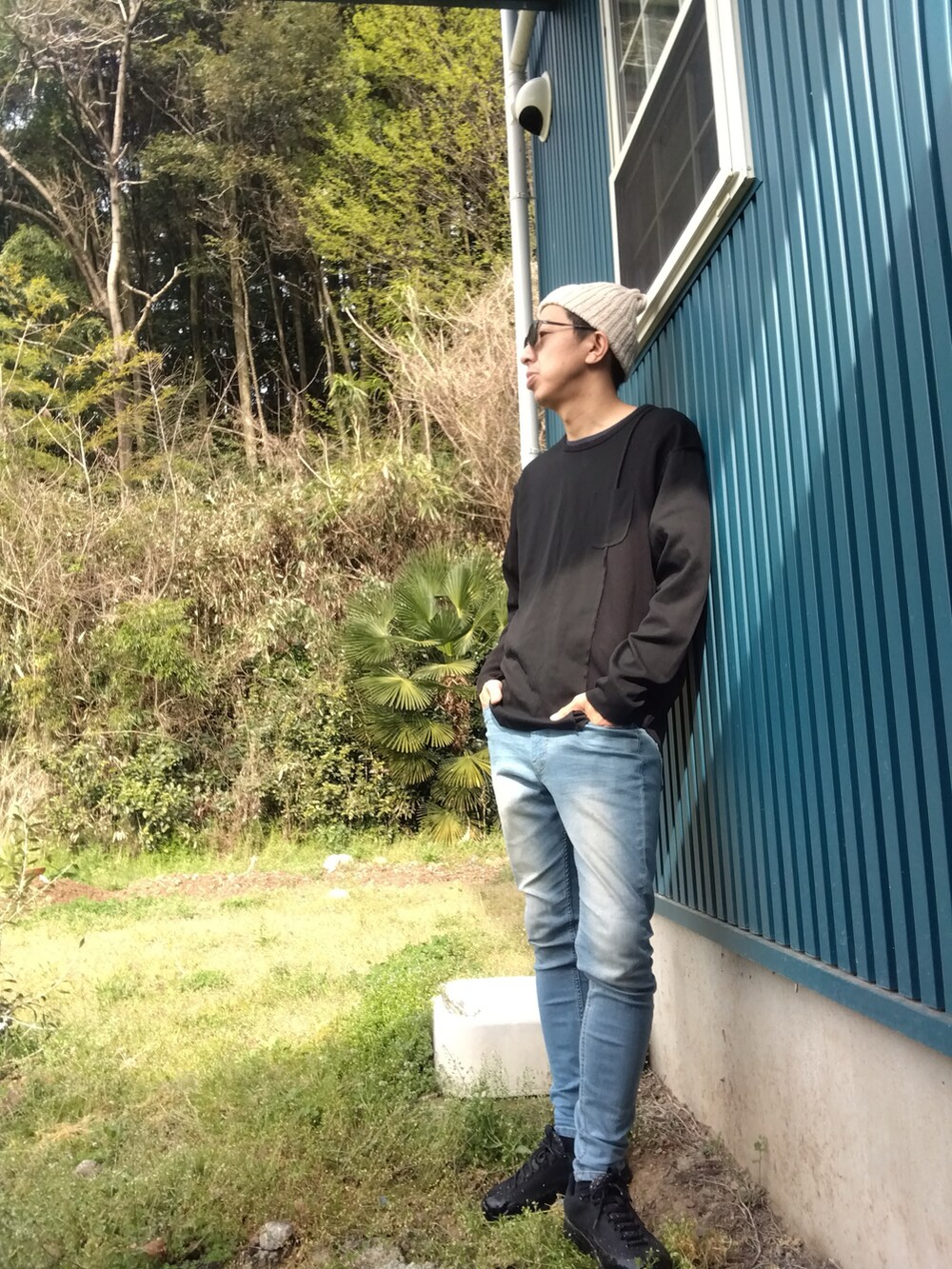 ブラック系のTシャツ/カットソー、ブルー系のデニムパンツ、ブラック系のスニーカーを着用したメンズの春コーディネートの2枚目の写真