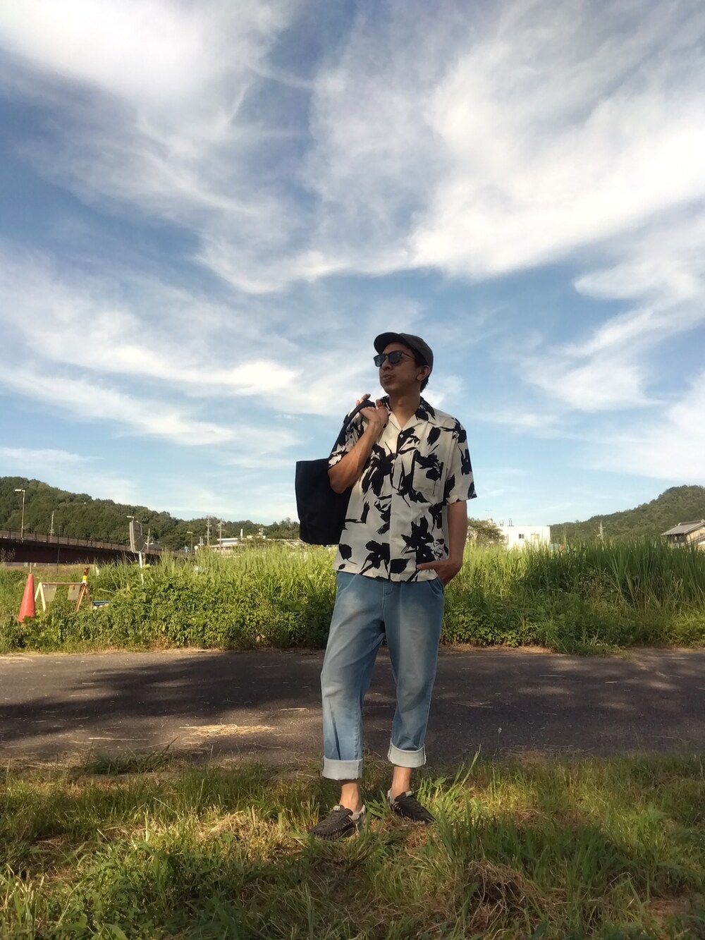 ホワイト系のシャツ/ブラウス、ブルー系のデニムパンツ、ブラック系のサンダルを着用したメンズの夏コーディネートの2枚目の写真