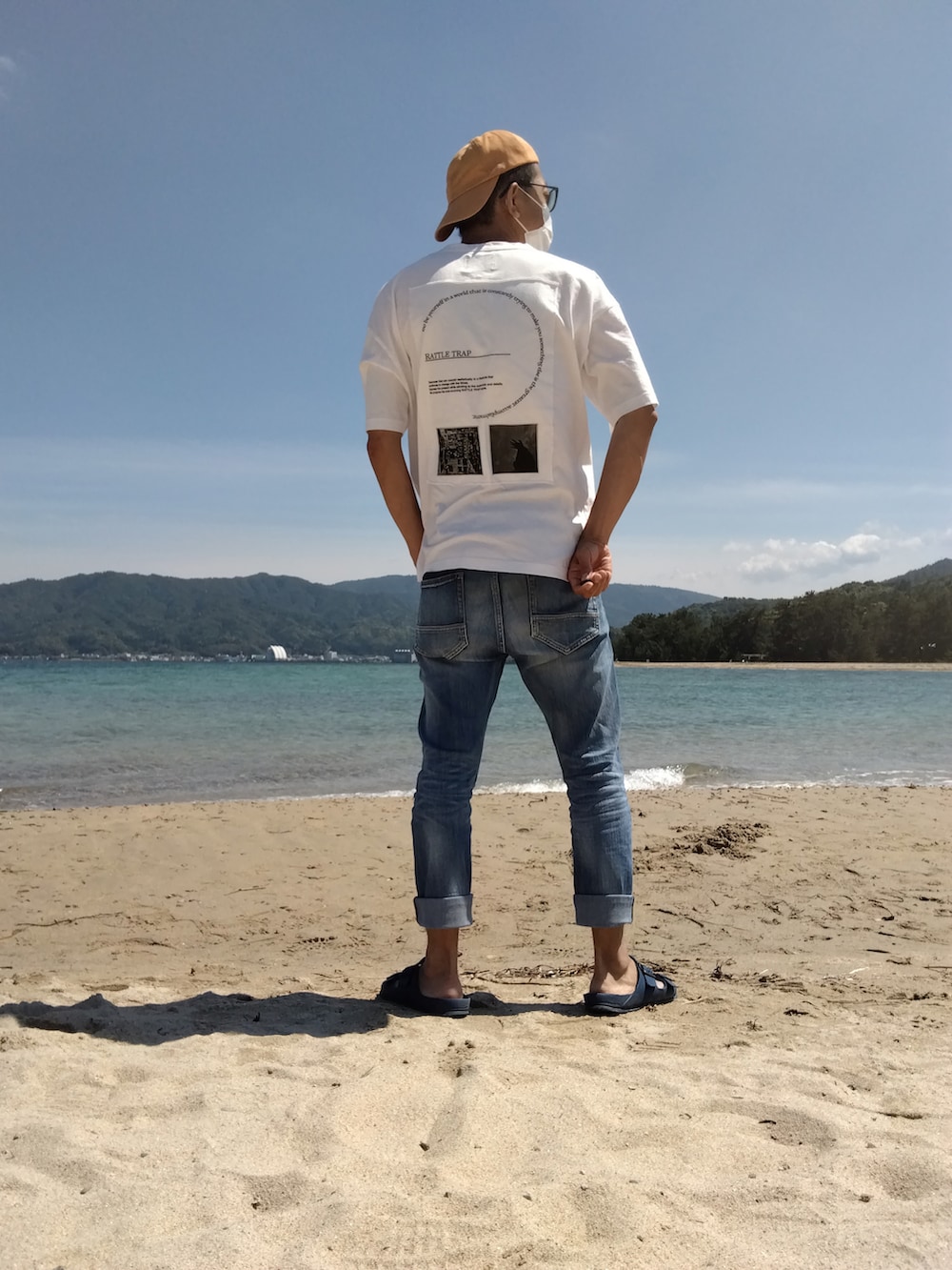 ホワイト系のTシャツ/カットソー、ブルー系のデニムパンツ、ブルー系のサンダルを着用したメンズの春コーディネートの3枚目の写真