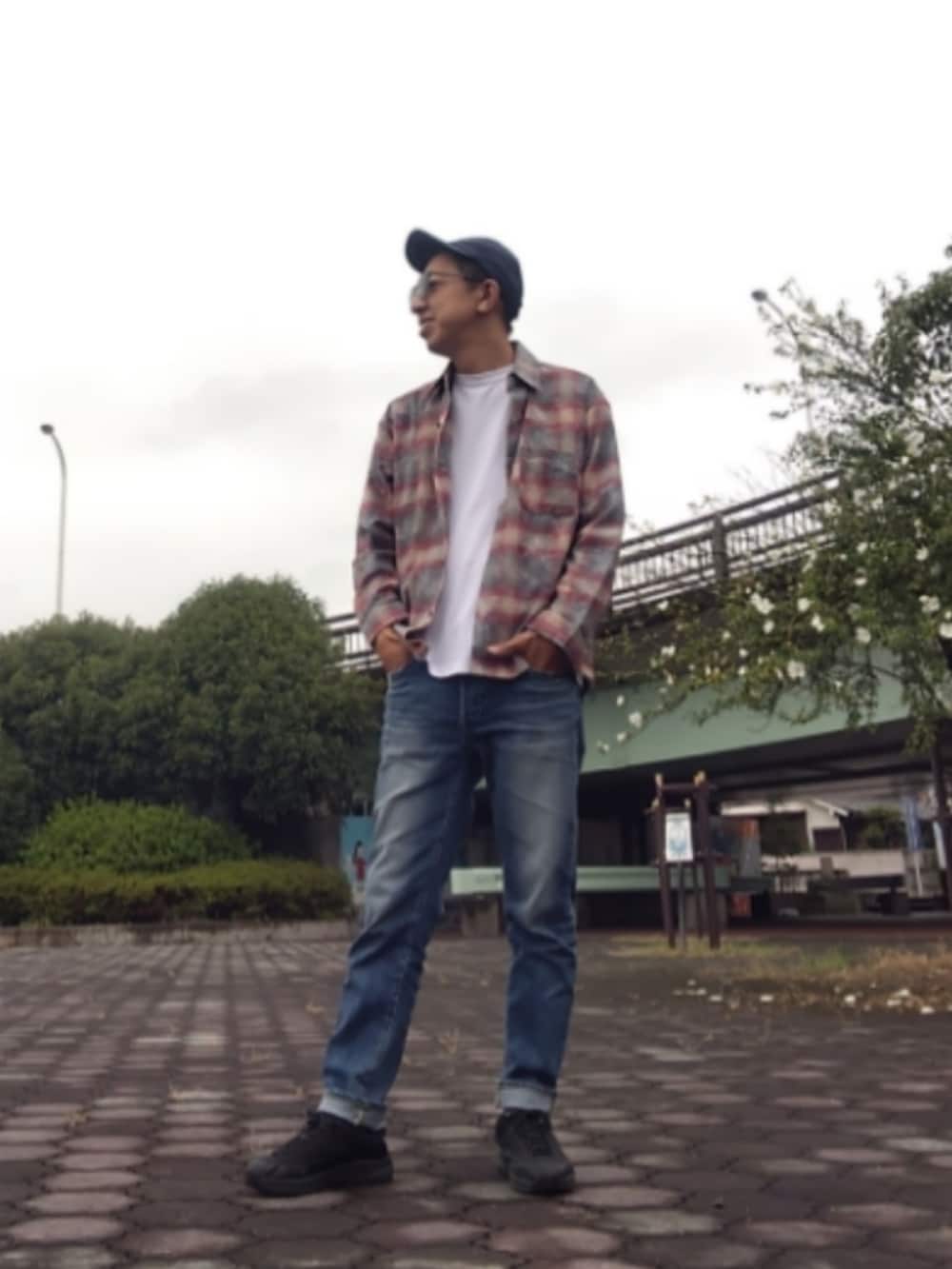 レッド系のシャツ/ブラウス、ブルー系のデニムパンツ、ブラック系のスニーカーを着用したメンズの秋コーディネートの2枚目の写真