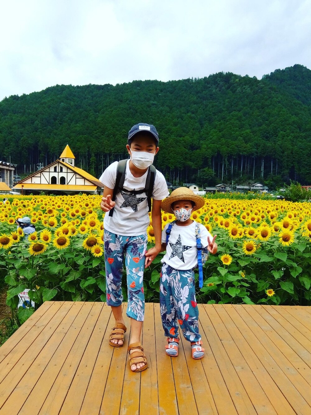 ホワイト系のTシャツ/カットソー、ブルー系のその他パンツ、ブラック系のサンダルを着用したメンズの夏コーディネートの3枚目の写真