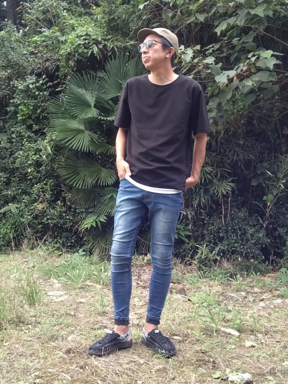 ブラック系のTシャツ/カットソー、ブルー系のデニムパンツ、ブラック系のサンダルを着用したメンズの秋コーディネートの2枚目の写真