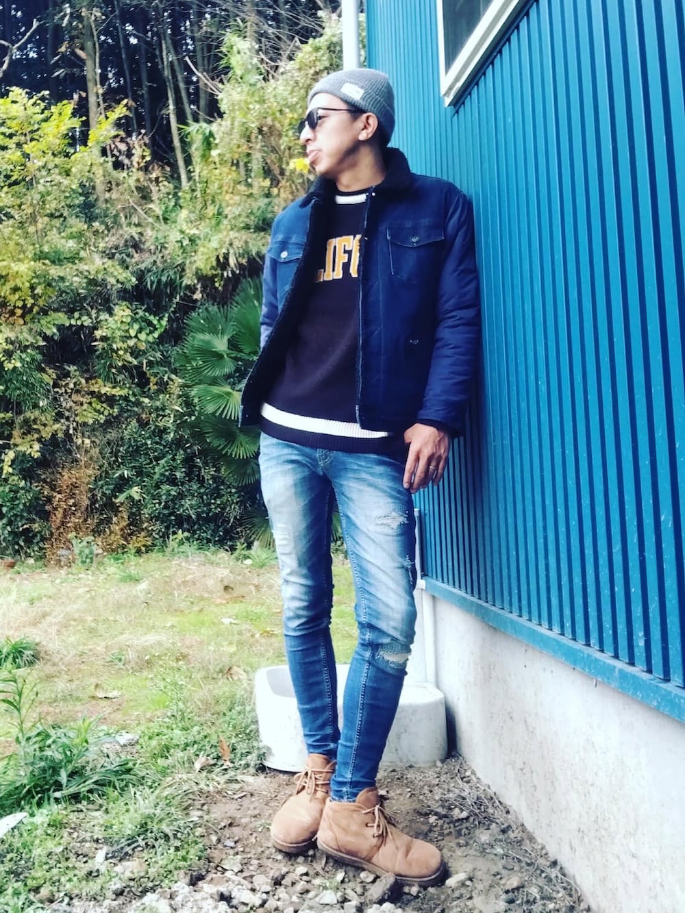 ブラック系のニット/セーター、ブルー系のブルゾン、ブルー系のデニムパンツを着用したメンズの冬コーディネートの2枚目の写真