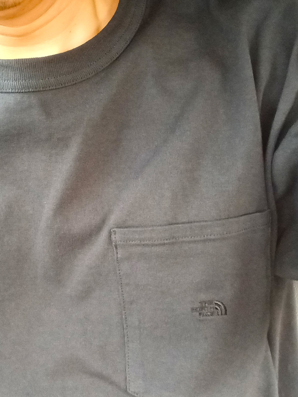 ブラック系のTシャツ/カットソー、ブルー系のデニムパンツ、ブラック系のサンダルを着用したメンズの秋コーディネートの2枚目の写真