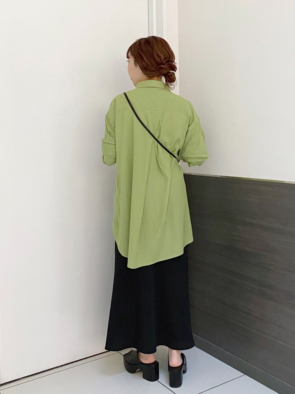 ブラック系のショルダーバッグ、ブラック系のスカート、ブラック系のサンダルを着用したレディースの春コーディネートの2枚目の写真