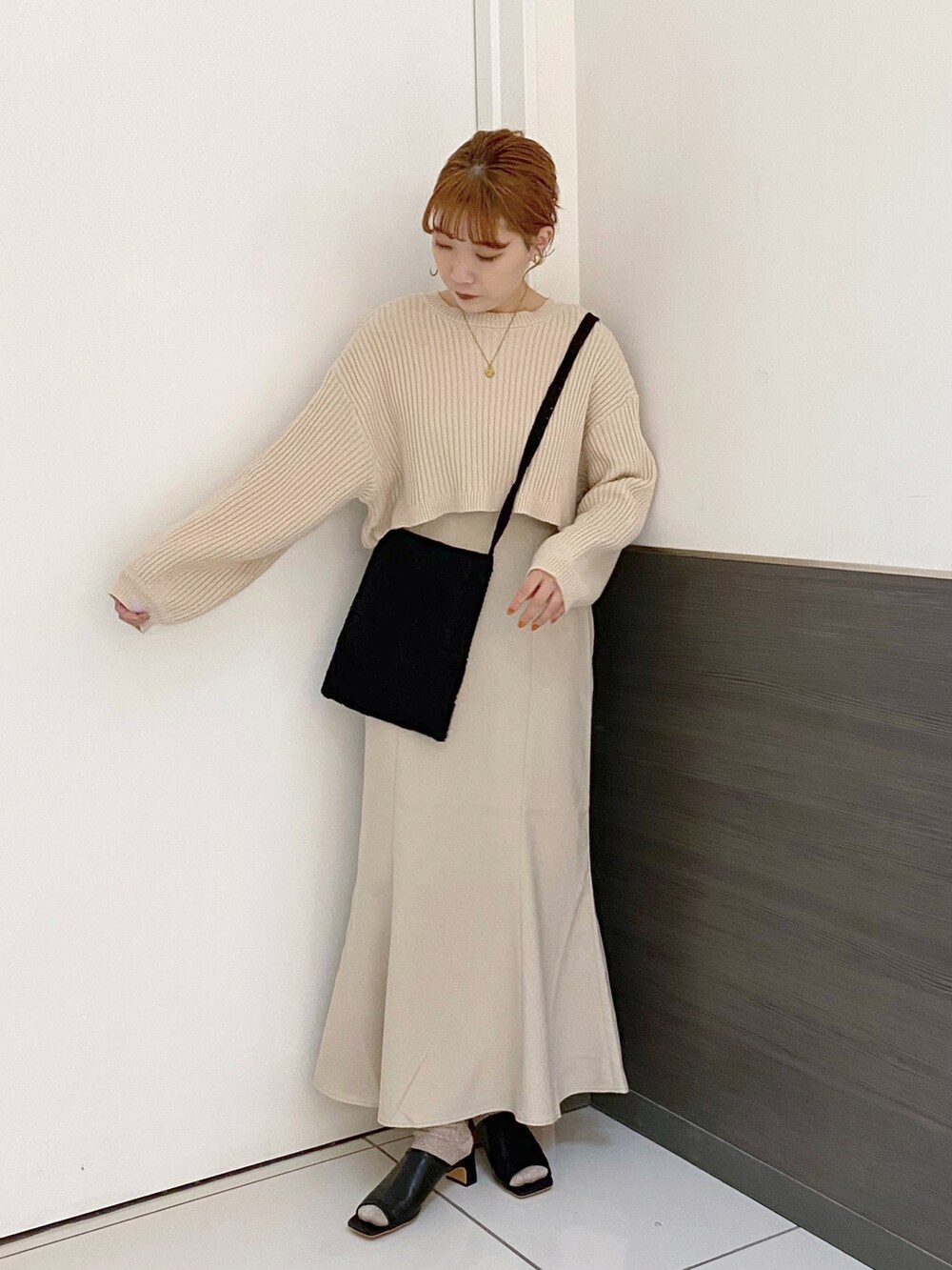 ホワイト系のスカート、ブラック系のサンダル、ブラック系のショルダーバッグを着用したレディースの春コーディネートの2枚目の写真