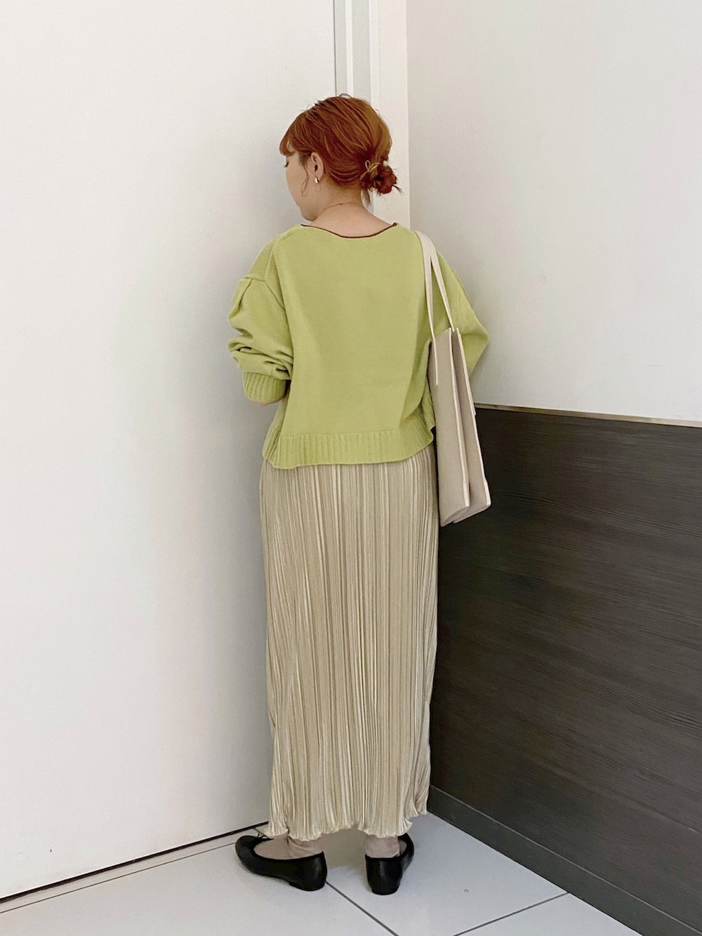 グリーン系のカーディガン/ボレロ、ホワイト系のスカート、ホワイト系のトートバッグを着用したレディースの春コーディネートの2枚目の写真