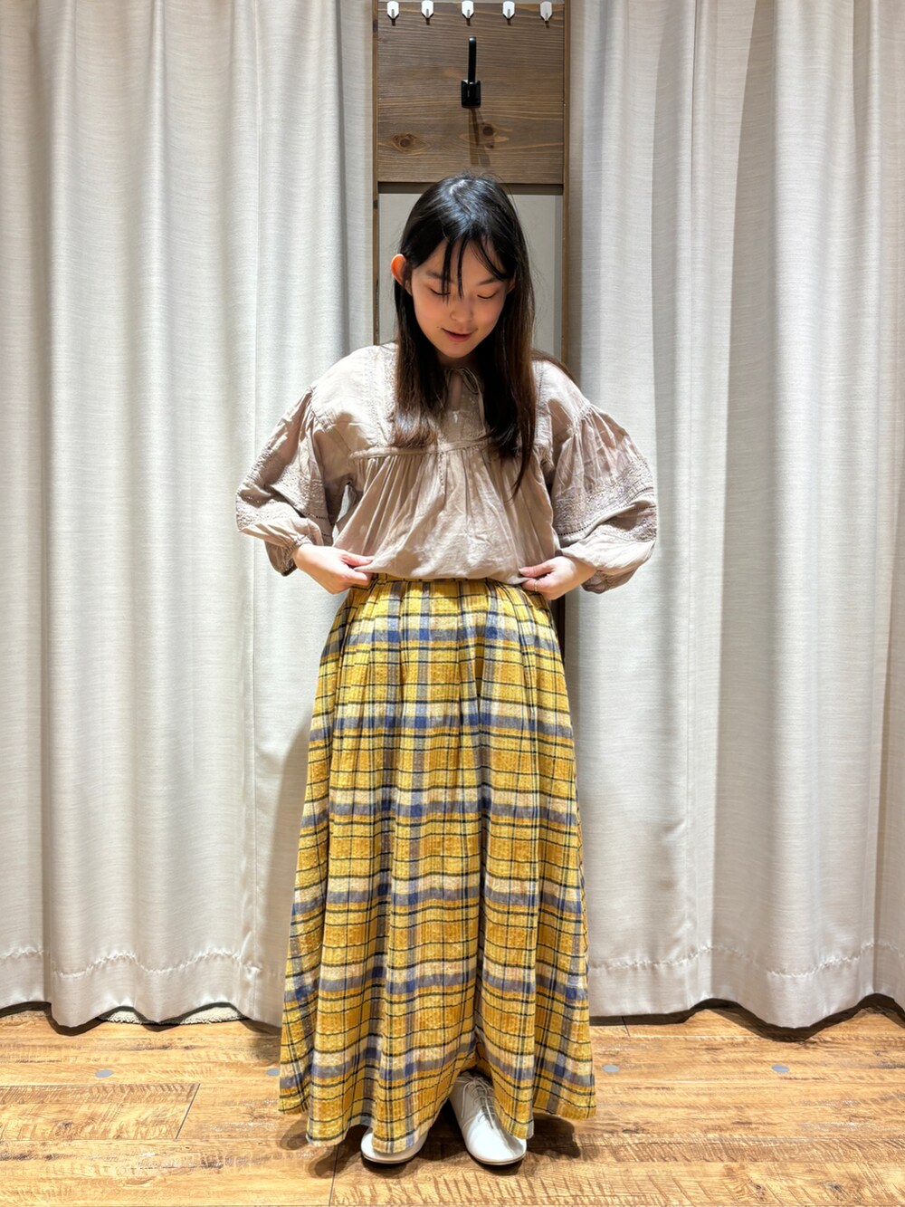 ホワイト系のシューズ、イエロー系のスカート、ベージュ系のシャツ/ブラウスを着用したレディースの春コーディネートの2枚目の写真